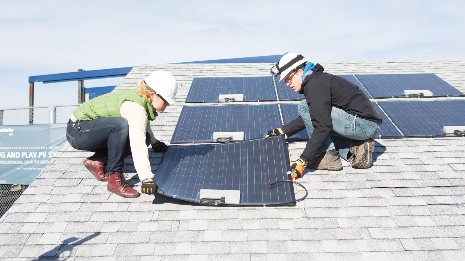 Researchers demonstrating Fraunhofer CSE's Plug & Play PV system on a roof